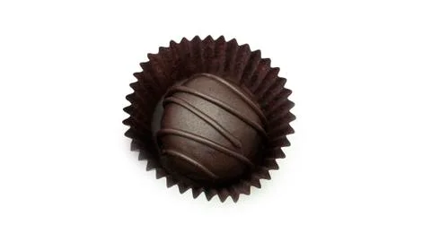 Delicious, round, chocolate candy in wrapper with nuts on a white background. Stock Photos