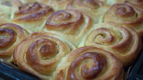 Delicious round cinnamon rolls on a baking sheet after the oven Stock Footage 246921537