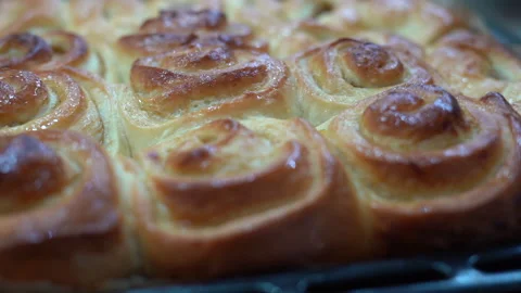 Delicious round cinnamon rolls on a baking sheet after the oven Stock Footage 262410850