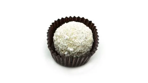 Delicious, round, coconut candy in wrapper with nuts on a white background. Stock Photos