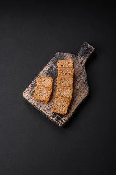 Delicious salted rectangular wheat croutons with salt and spices on a dark co Foto stock