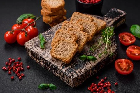 Delicious salted rectangular wheat croutons with salt and spices on a dark co 库存照片