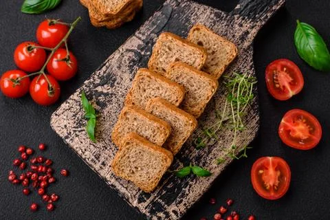 Delicious salted rectangular wheat croutons with salt and spices on a dark co Stockfoto's