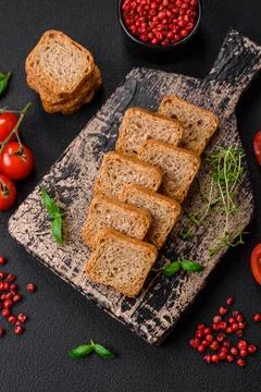 Delicious salted rectangular wheat croutons with salt and spices on a dark co Foto stock