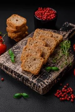 Delicious salted rectangular wheat croutons with salt and spices on a dark co Stockfoto's