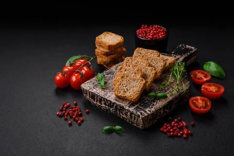 Delicious salted rectangular wheat croutons with salt and spices on a dark co Foto stock