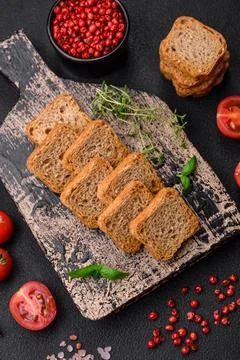 Delicious salted rectangular wheat croutons with salt and spices on a dark co Stockfoto's