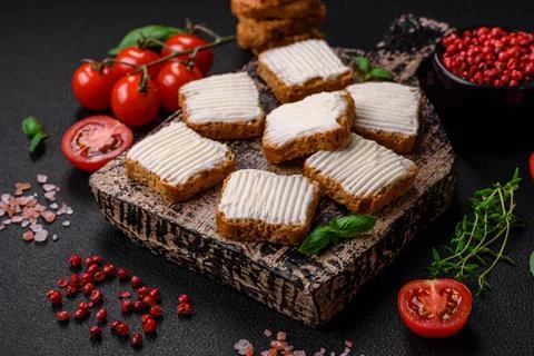 Delicious salty rectangular wheat croutons with cream cheese, tomatoes, salt  Stock Photos