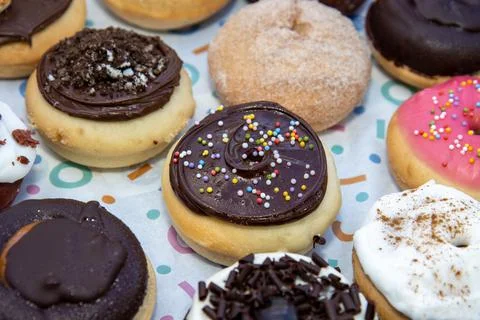A delicious selection of colourful doughnuts including a chocolate one with s Stock Photos