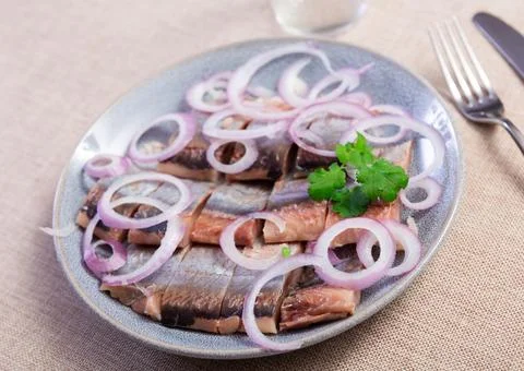 Delicious serving of seared herring with some onion on side 스톡 사진