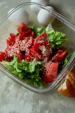 Delicious, simple and nutritious meal. Fresh tomato salad, baguette and boiled Stock Photos