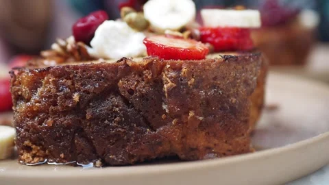 A delicious slice of banana bread topped with fresh fruits like strawberries and Stock Footage 289606563