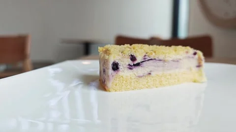 A delicious slice of blueberry crumble cake served inside a cafe. Vídeos de archivo 344747074