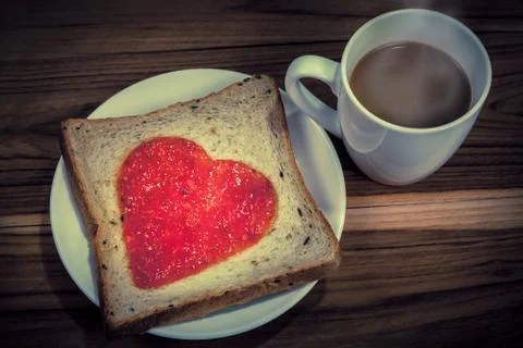 Delicious slice of bread with strawberry jam heart shape Stock Photos