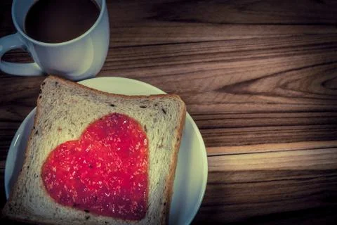 Delicious slice of bread with strawberry jam heart shape Foto stock