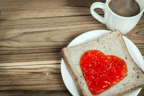 Delicious slice of bread with strawberry jam heart shape Stock-Fotos