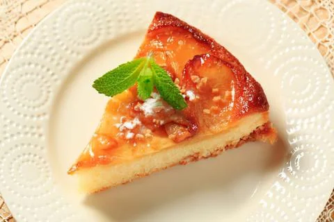 Delicious slice of caramelized peach cake on plate Stock Photos