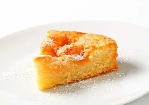 Delicious slice of dusted cake on white plate Stock Photos