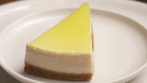 Delicious slice of lemon cheesecake with a graham cracker crust Stock Footage 335375367