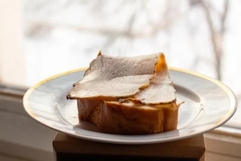 A delicious slice of roast beef on bread with golden crust served on a plat 스톡 사진