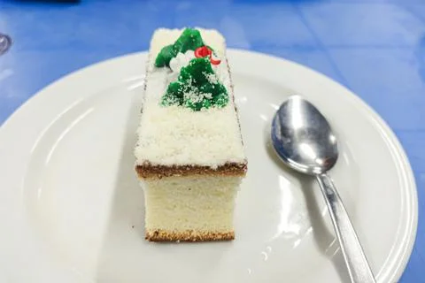 Delicious Slice of Vanilla Sponge Cake with Cream and Green Icing on White Plate Stock Photos