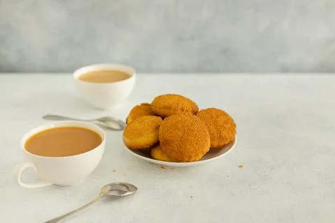Delicious snack: two cups of black tea with milk and a plate of cookies on a Stock Photos