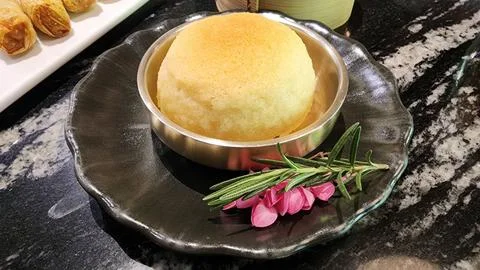 Delicious soft bread roll served on elegant black plate with garnish Stock Photos