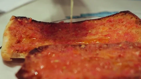 Delicious spanish tapas with smashed tomatoes with olive oil close-up. Pan con Stock Footage 321757117
