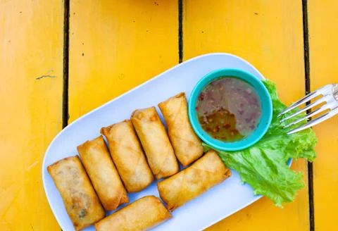 Delicious spring rolls on a yellow table - happy meal Stock Photos