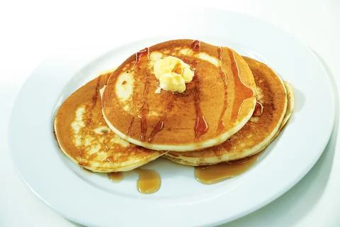 Delicious stack of pancakes with butter and syrup on white plate Stock Photos