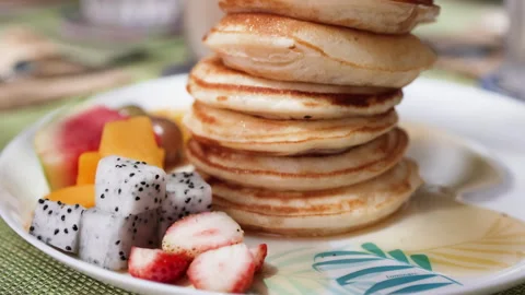 Delicious stack of pancakes topped with array of tropical fruits. Stock Footage 288063836
