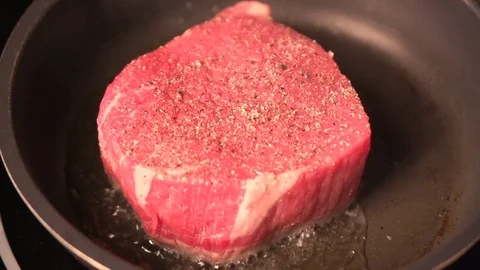 Delicious steak placed on hot grill garnished with salt and pepper. Close up Stock Footage 73855472
