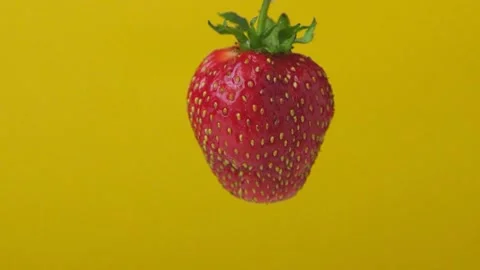 A delicious strawberry on a yellow background Stock Footage 135578835