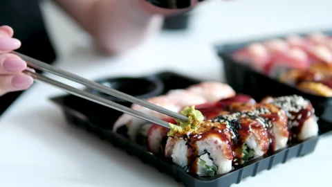 Delicious sushi set with eel and rich unagi sauce served in black containers Stock Footage 346190553