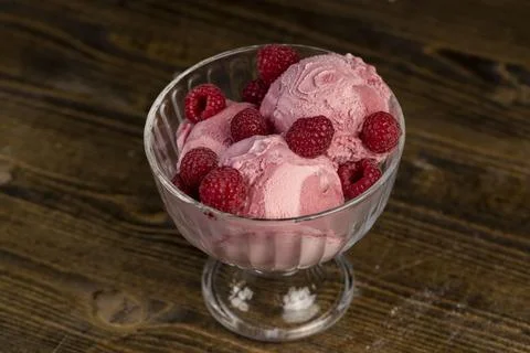 Delicious sweet cold raspberry flavored ice cream and ripe raspberries in a.. Foto stock