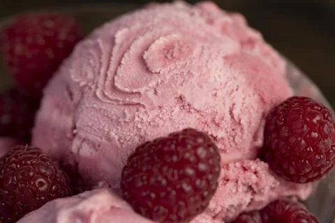Delicious sweet cold raspberry  flavored ice cream and ripe raspberries in .. Stock Photos