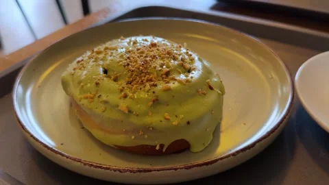 Delicious sweet mini cake sprinkled with pistachios in a bakery. Fresh bun with Stock Footage 314107066