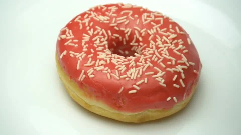 Delicious sweet red donut rotating on a plate. Pouring chocolate. Side view Stock Footage 86128341