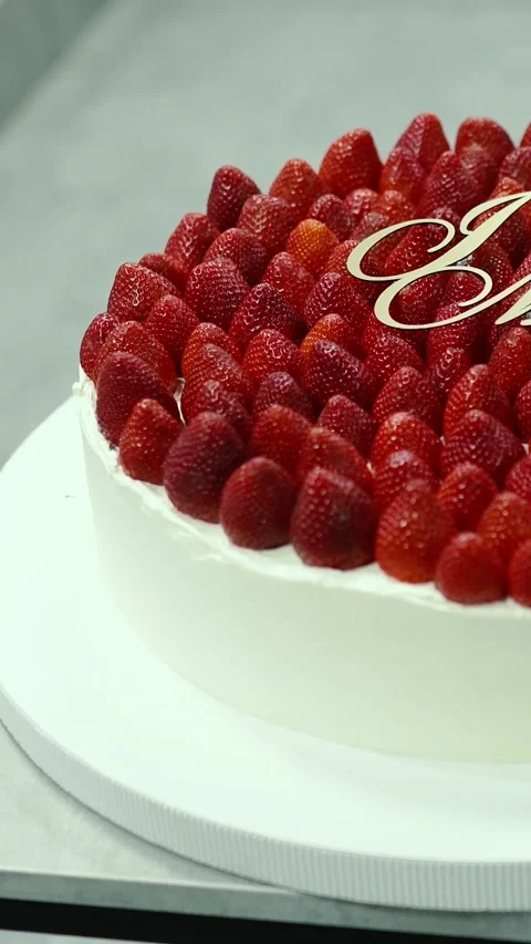 A delicious, sweet wedding cake with white cream, red strawberries Видео 336731237