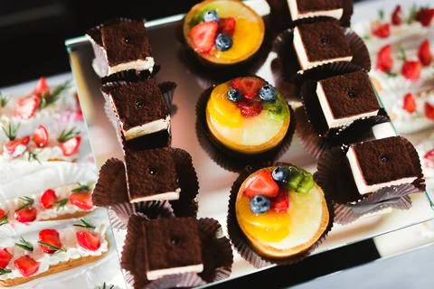 Delicious sweets on wedding candy buffet with desserts, cupcakes Stock Photos