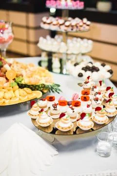Delicious sweets on wedding candy buffet with desserts, cupcakes Stock Photos