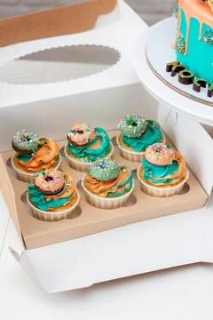 Delicious two-sided birthday cupcakes made in green and orange colors richl.. Stock Photos
