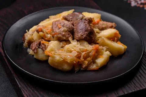 Delicious vegetable stew with beef, potatoes, carrots and cabbage in a blac.. Stock Photos