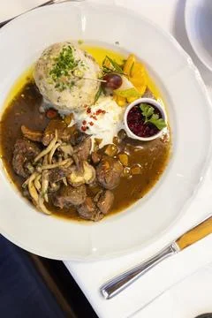 Delicious venison stew with bread dumpling, lingonberry sauce and horseradi.. Stock Photos