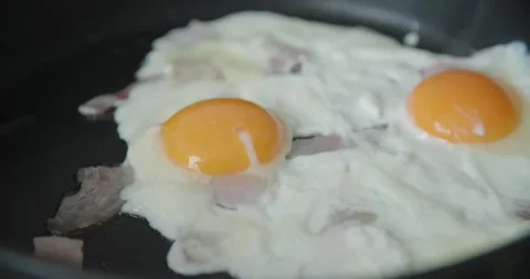Deliciously Fried Egg Accompanied by Crispy Bacon in Pan Stock Footage 302478984