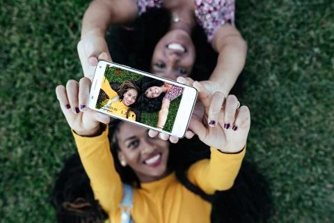 Delighted African American women taking selfie on grass Stock Photos