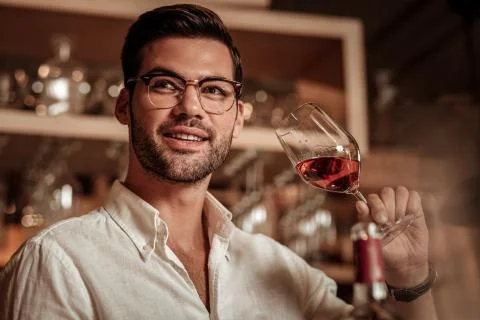 Delighted bearded young man going to taste champagne 库存照片
