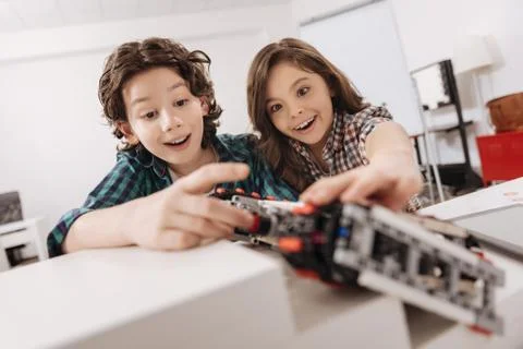 Delighted children programming electronic robot in the studio Foto stock