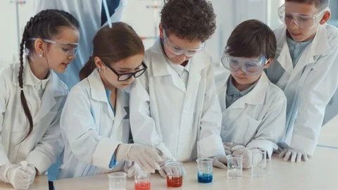 Delighted children in protective suits studying science at a school lab. Close Stock Footage 111544397