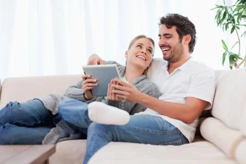 Delighted couple using a tablet computer Stockfoto's